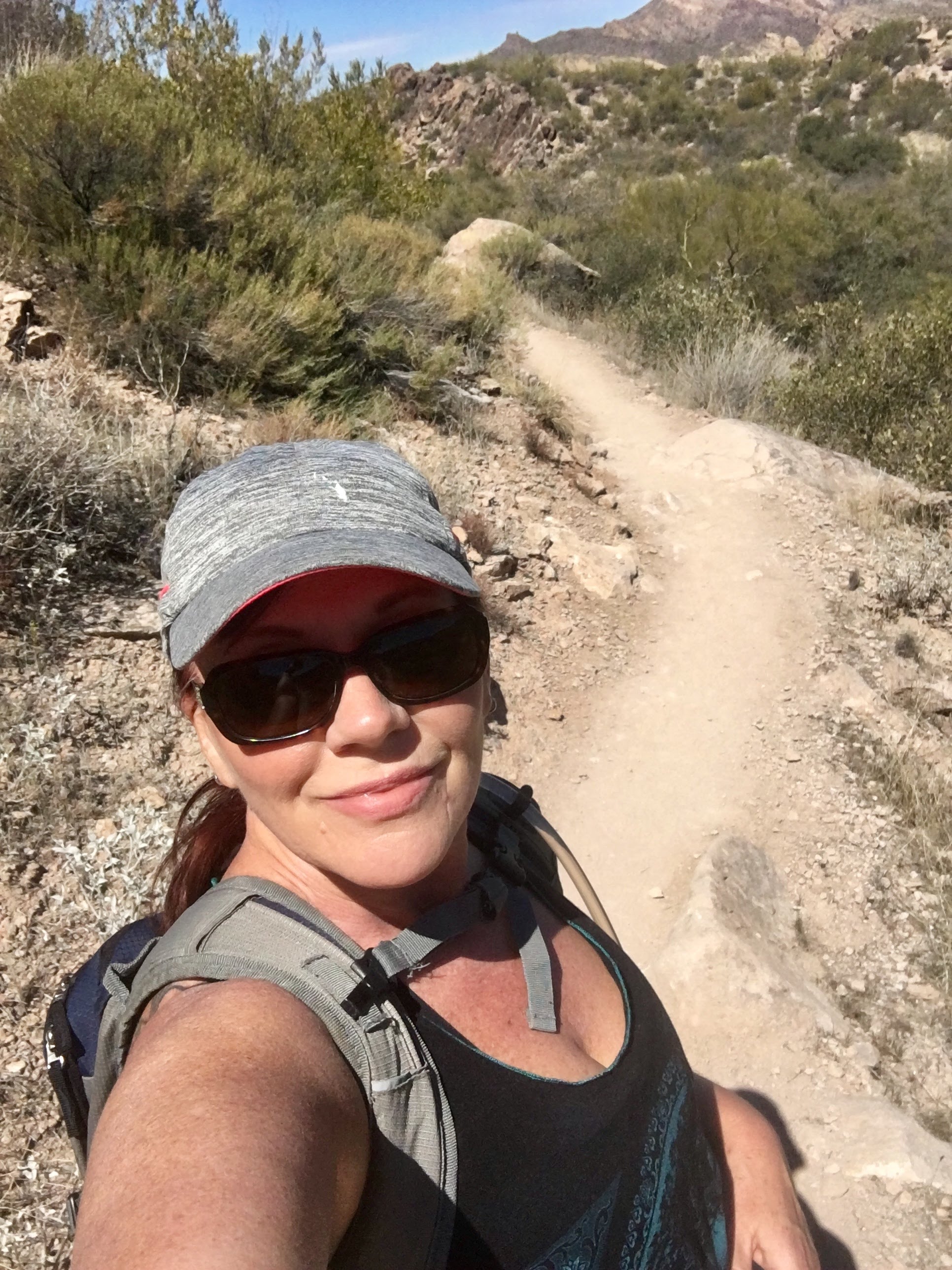 Woman hiking under the Arizona sun, rediscovering freedom and strength through movement.