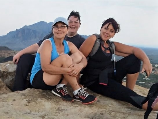 Three women resting together during a Chubby Chicks Fitness hike in Arizona.
