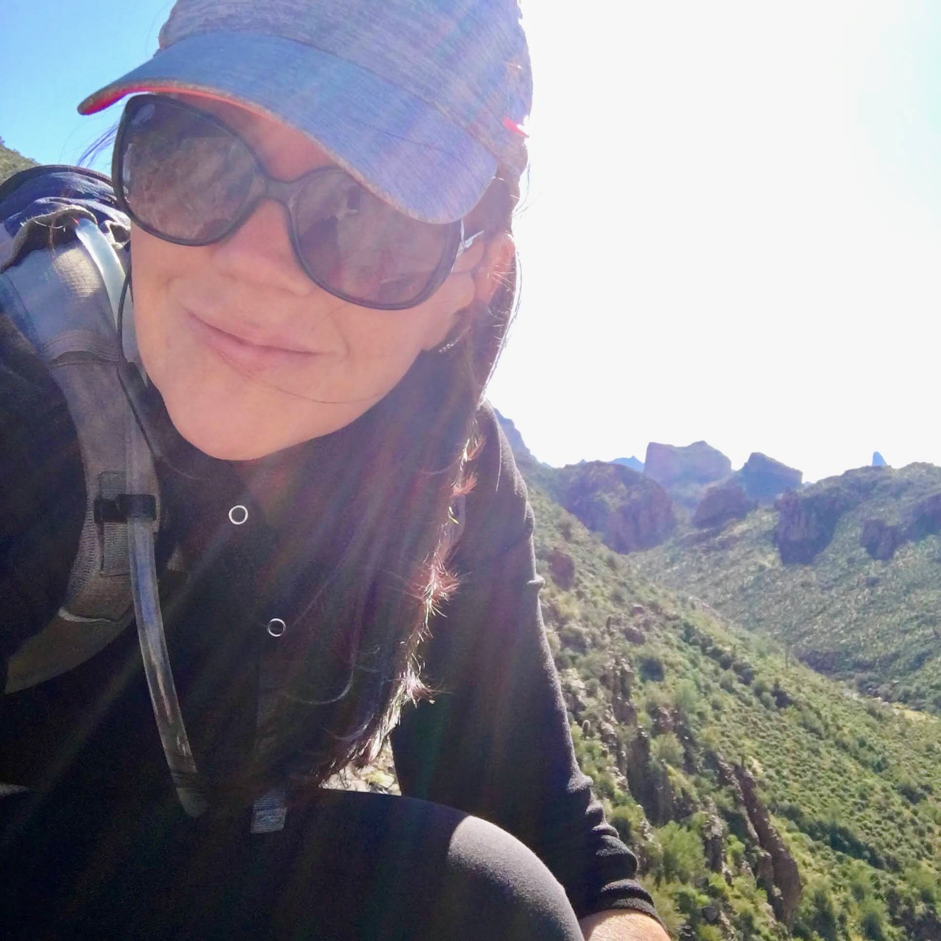 Coree Silvera sitting on top of hiking trail and smiling